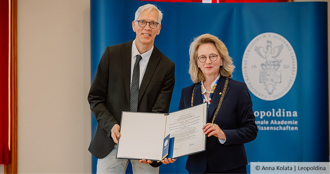 Ein Mann und eine Frau halten eine Urkunde vor sich.